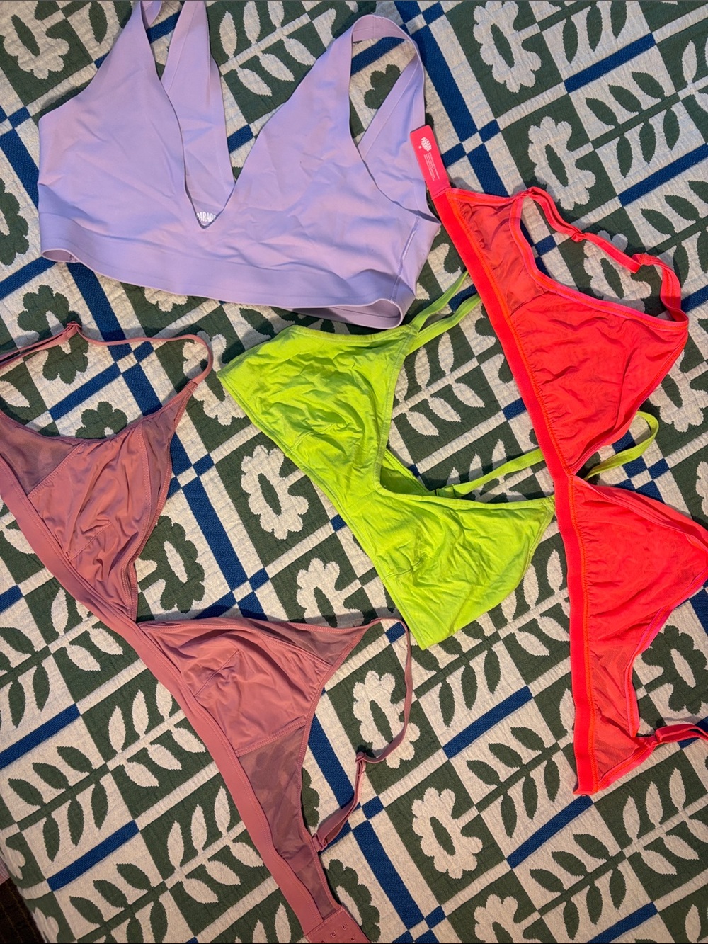 Four Parade Bras in Medium: purple, mauve, lime green, and bright coral